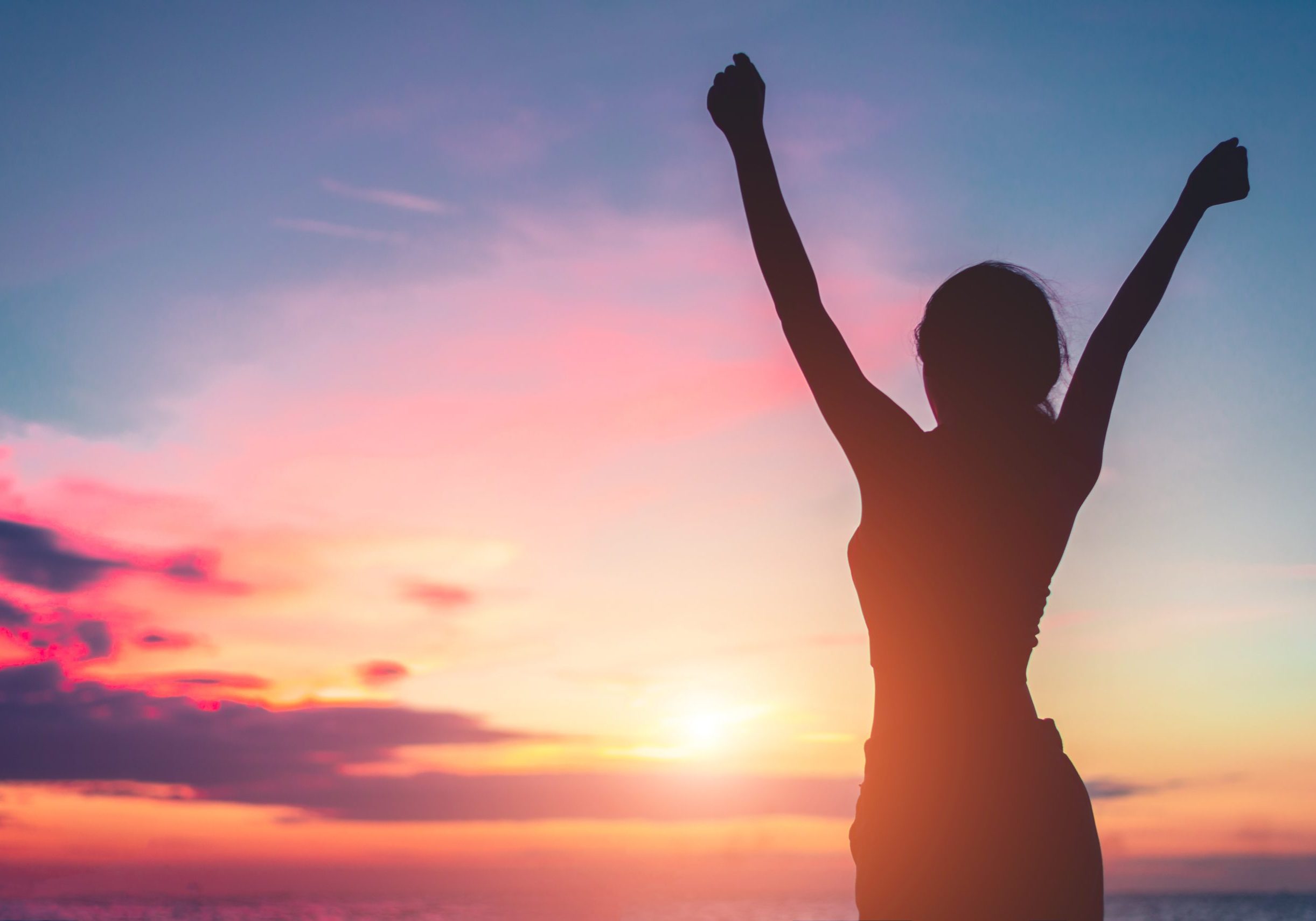 Happy woman standing arms outstretched back and enjoy life on the beach at Sea